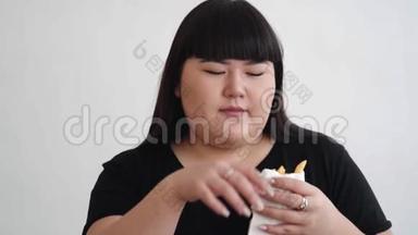 亚洲黑衬衫女人喜欢手里拿着炸薯条吃饭。 快乐概念